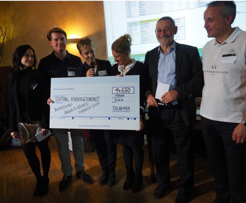 Scheckübergabe an die Stiftung auf dem Bayerischen Anwalts-Kickerturnier 2017; v.l.n.r.: Dr. jur. (Ung.) F. Weinhardt (Kanzlei Wach + Meckes LLP), Dr. M. Braun (Kanzlei Gleiss Lutz), 