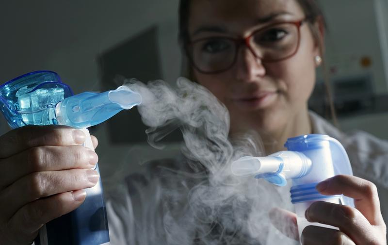 Pharmaceutical PhD student Julia Ernst with inhalers of a nanoparticle suspension. Jena researchers are developing an efficient method for treating often deadly respiratory infections. 