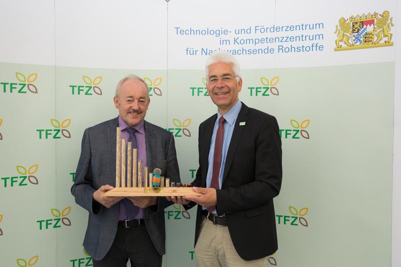 Dr. Widmann, Leiter des Technologie- und Förderzentrums (rechts) überreichte Franz Kustner eine TFZ-Brennstofforgel als Auszeichnung für sein jahrzehntelanges Engagement für Nachwachsende Rohstoffe