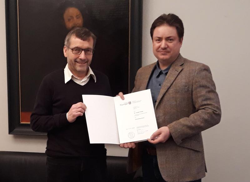 Prof. Walter Rosenthal, Präsident der Friedrich-Schiller-Universität Jena, überreicht Prof. Tomáš Čižmár die Urkunde über die Ernennung zum Professor für Wellenleiteroptik. 