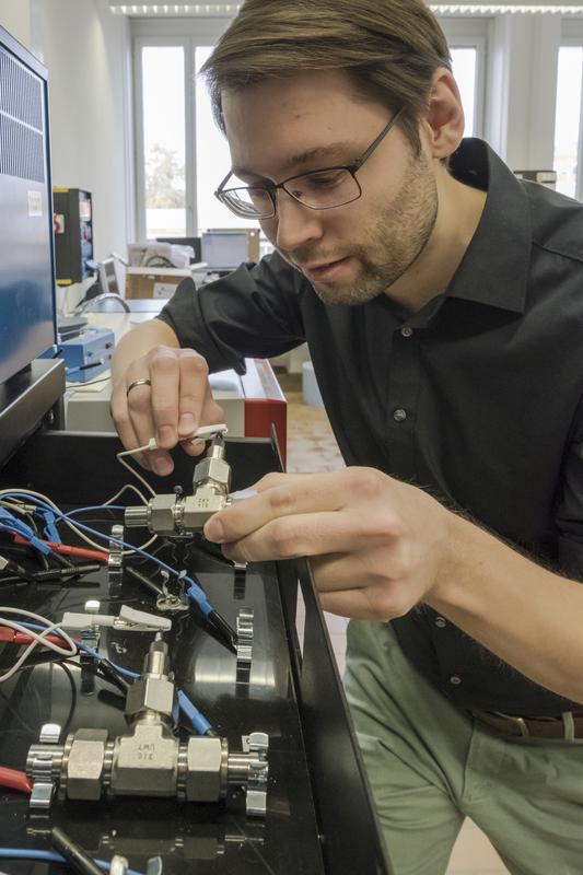Research on the water electrolyte: Empa researcher Ruben-Simon Kühnel connecting a test cell to the charger with the concentrated saline solution. 