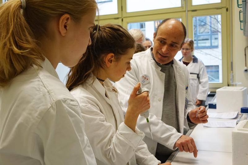 Prof. Dr. Otmar Huber (rechts), Direktor des Instituts für Biochemie II, erklärt, worauf beim Pipettieren zu achten ist. 