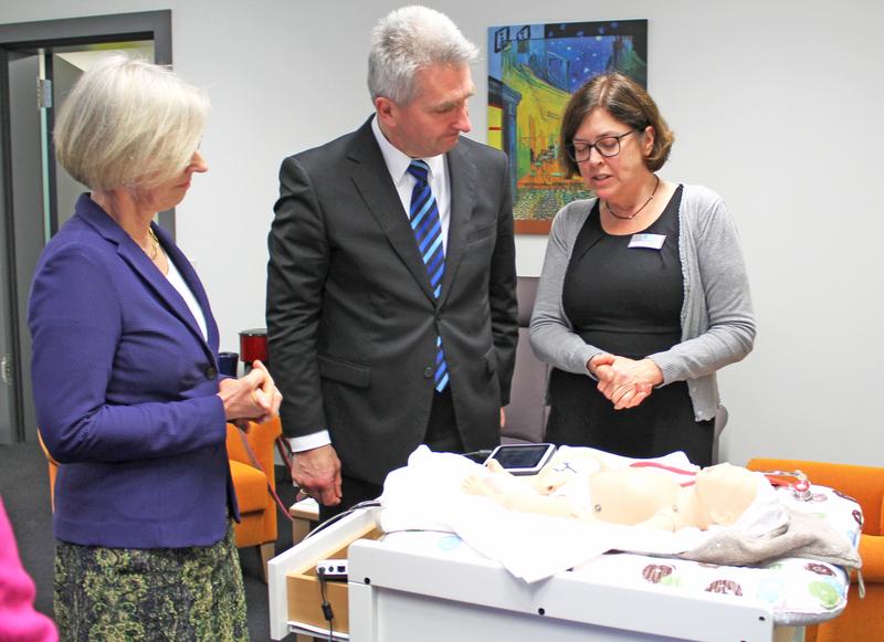 Prof. Dr. Nicola Bauer (rechts im Bild) stellte dem Minister einen Neugeborenen-Simulator vor. hsg-Präsidentin Anne Friedrichs (im Bild links) und Minister Pinkwart konnten die Atmung sehen.