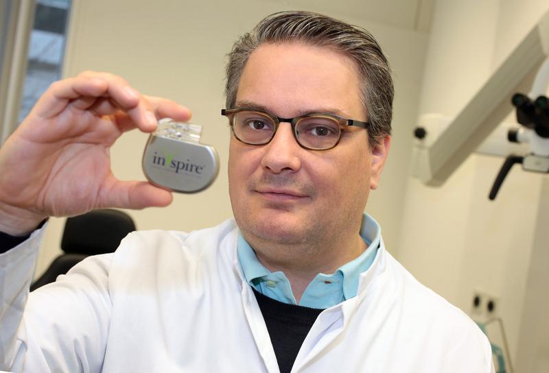 Dr. Christian Plettenberg, Oberarzt der Klinik für Hals- Nasen-  und Ohrenheilkunde am UKD, präsentiert einen der Schrittmacher, die gegen Schlafapnoe eingesetzt werden. 