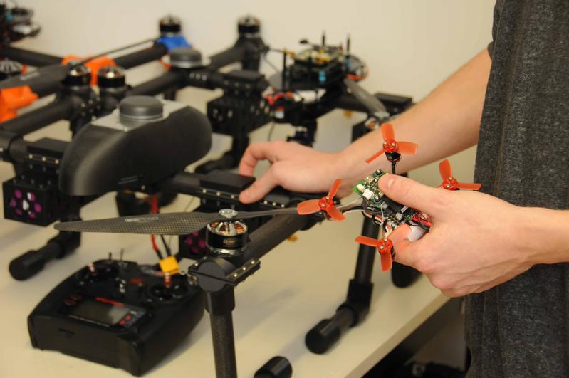 Mit Mikro-Drohnen üben die Wissenschaftler den Formationsflug. Im Hintergrund die Drohnen, die später zum Einsatz kommen sollen. 