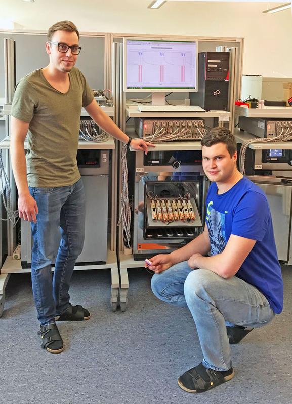 TTZ-EMO Mitarbeiter David Oeser und Andreas Ziegler mit einem der bestehenden Batterieprüfsysteme 