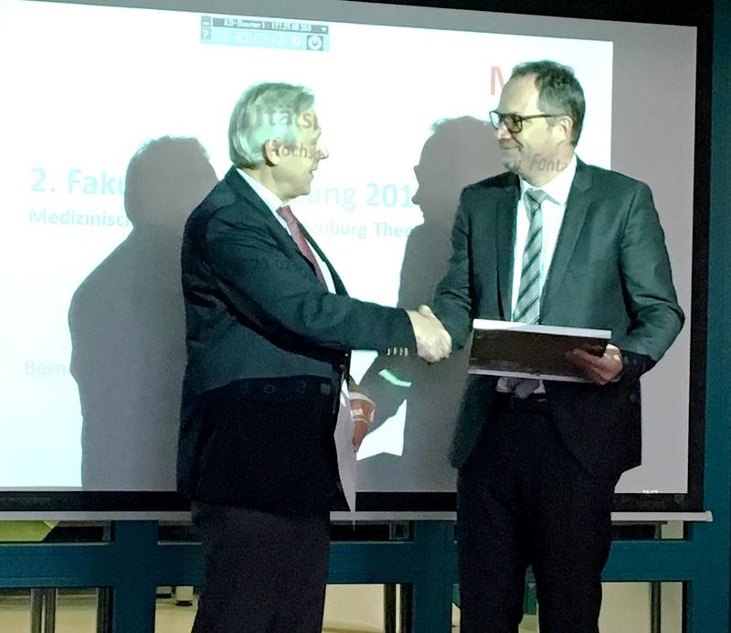 Prof. Dr. Christian Wenger (r.) bekommt vom Dekan der Medizinischen Hochschule Brandenburg Theodor Fontane Prof. Dr. Edmund Neugebauer (l.) die Ernennungsurkunde überreicht.