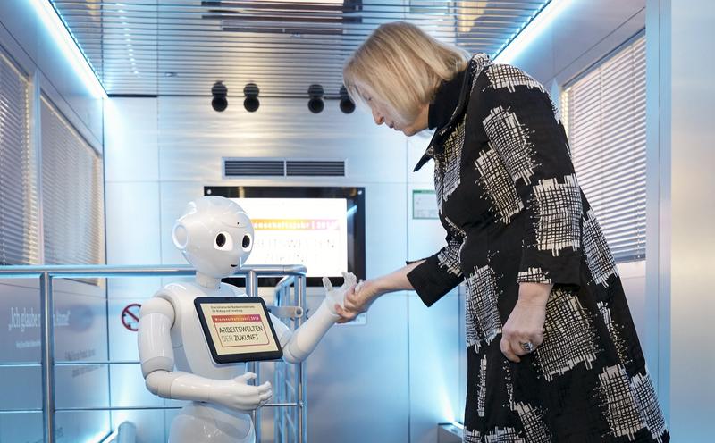 „Mensch-Maschine-Interaktion: Bundesforschungsministerin Johanna Wanka wird von dem humanoiden Pepper-Roboter „Emma“ im Ausstellungsfahrzeug InnoTruck beim Auftakt des Wissenschaftsjahres 2018 – Arb