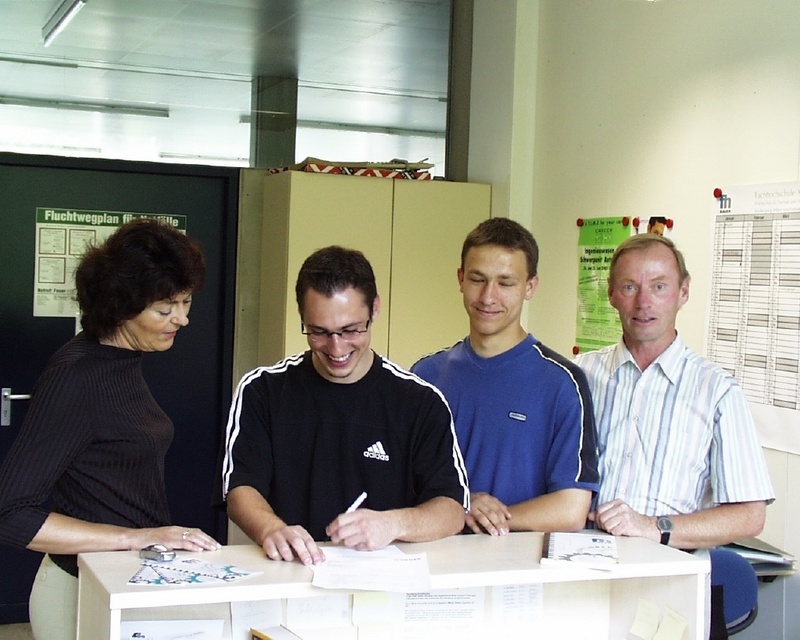 Die Pioniere des dualen Studiengangs Mechatronik Stefan Hald und Tobias Landkammer - dabei der Studiengangsverantwortliche Prof. Peter Gerloff und Fachbereichs-Sekretärin Inge Beiler. (Foto: Röhm)