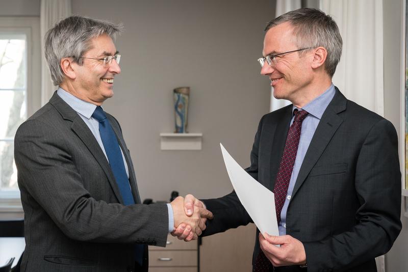 Prof. Hans Müller-Steinhagen, Rektor der TU Dresden, überreicht die Berufungsurkunde an Prof. Hanno Glimm.