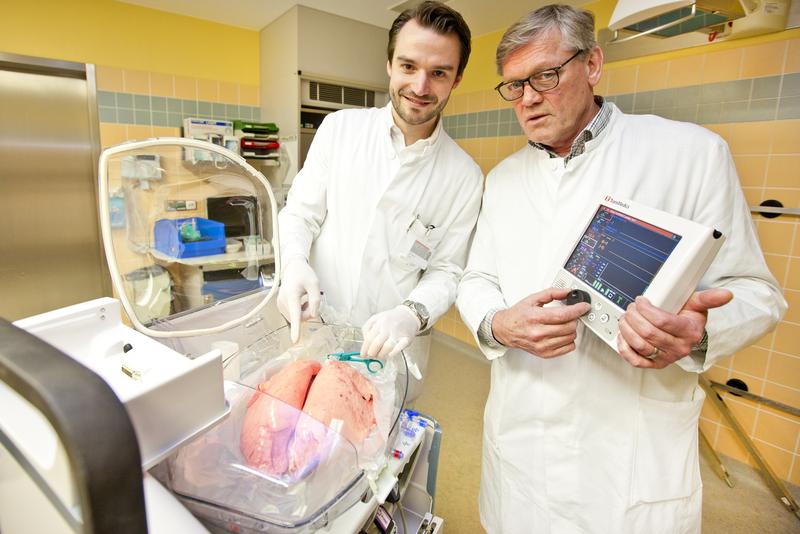  Dr. Norman Zinne (links) und Professor Dr. Axel Haverich an einem Organ Care System (OCS), das eine Schweinelunge enthält. Professor Haverich hält die Steuereinheit für das OCS.