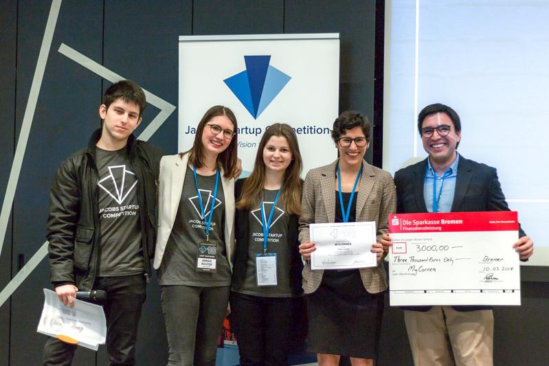 Moderator Alex Smith, die Hauptorganisatorinnen Annika Richter und Lara König sowie das Siegerteam Maria Teresa Perez Zaballos und Daniel Morales Valdivia. Foto: Jacobs University / Dragi Kamov