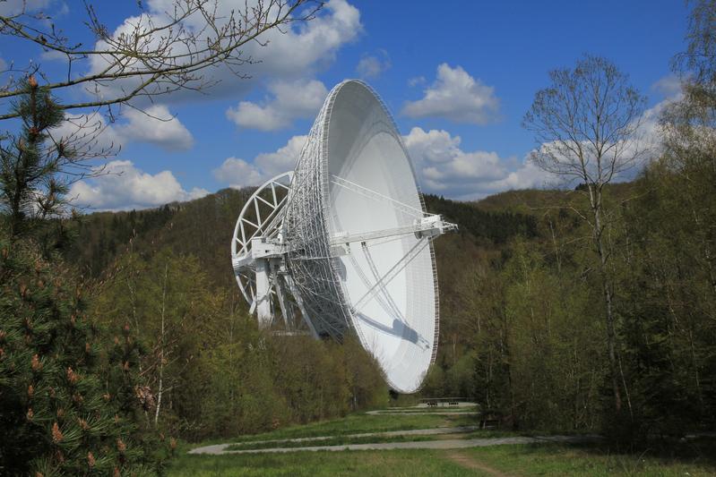 Das 100-m-Radioteleskop Effelsberg vom Besucherpavillon aus gesehen. Von dort führt ein zickzackförmiger Weg bis zum Aussichtspunkt unmittelbar vor dem großen Reflektor.