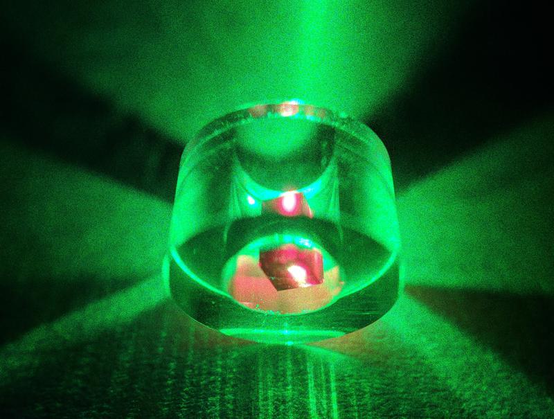 Um eine Maserwirkung zu erzielen, wurde ein Diamant in einem Saphirring platziert und mit grünem Licht eines Lasers bestrahlt. Der Diamant erscheint aufgrund der Fluoreszenz nach Anregung rot.