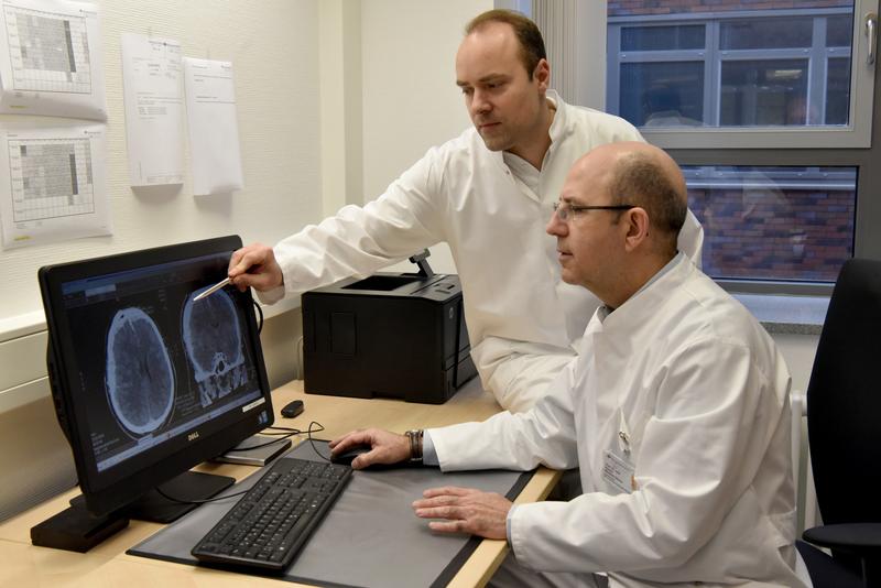 Studienleiter Prof. Dr. Ramón Martínez-Olivera (vorne) mit Oberarzt Dr. Bogdan Pintea bei der Befundung einer Computertomografie des Kopfes nach einem Schädel-Hirn-Trauma