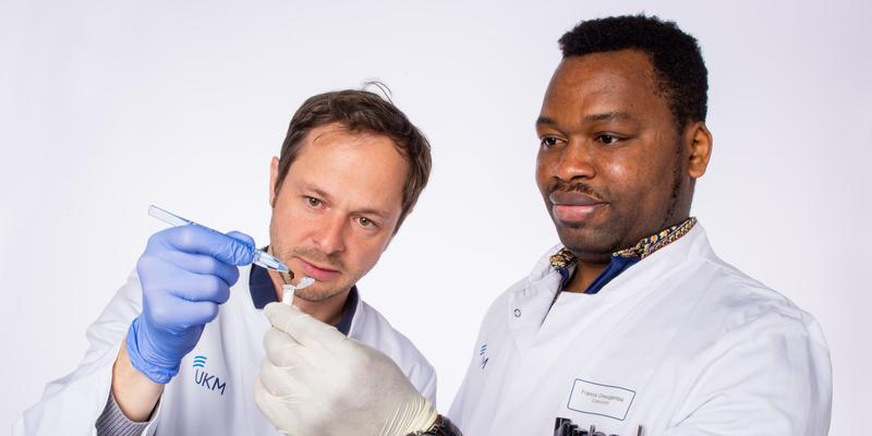 Prof. Frieder Schaumburg und Francis Onwugamba, PhD-Student aus Nigeria, bei der Untersuchung einer Fliege