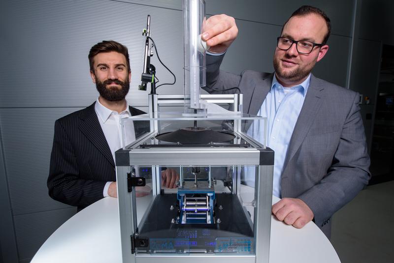 Mit dieser Apparatur zeigen die Ingenieure Paul Motzki (l.) und Philipp Linnebach (r.) die neue Technologie auf der Hannover Messe: Hierzu lassen sie einen Ball auf die Folie fallen.