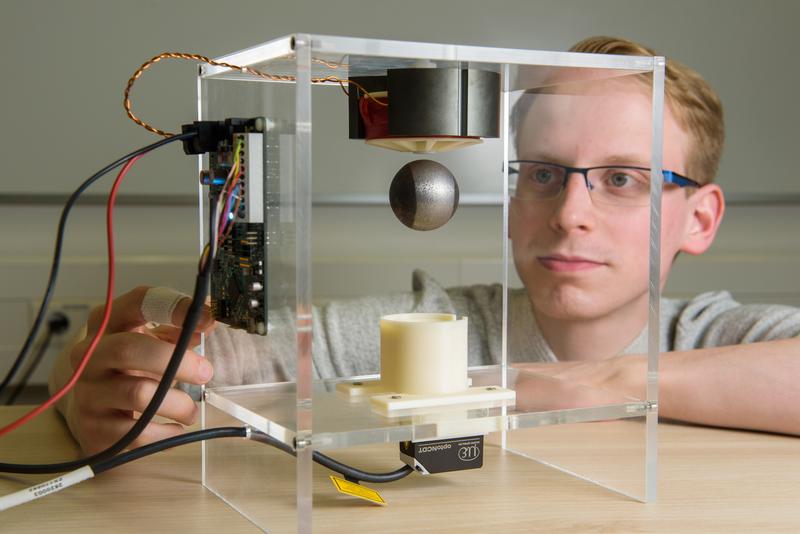Niklas König, a research assistant in Prof. Nienhaus’ group, demonstrates the precision of the new sensor-free technology by levitating a steel ball.