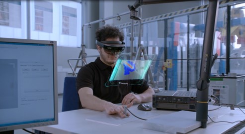 Der Wissenschaftler Ali Movahed bei der Prüfung eines Bauteils auf Fehler im Materialinneren mit einer Augmented Reality-Brille (AR).