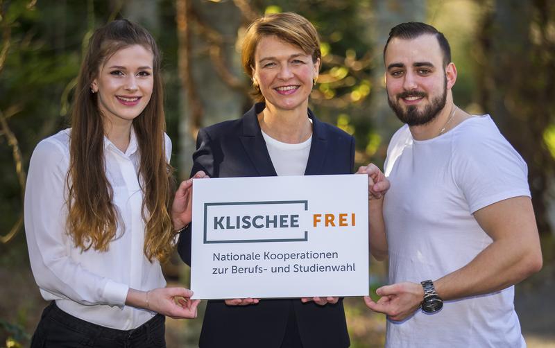 Elke Büdenbender mit Jessica Gosse (links) und Alexander Tyzaj (rechts). Die junge Frau und der junge Mann haben sich für einen Beruf entschieden, in dem eher wenig Frauen bzw. Männer arbeiten.