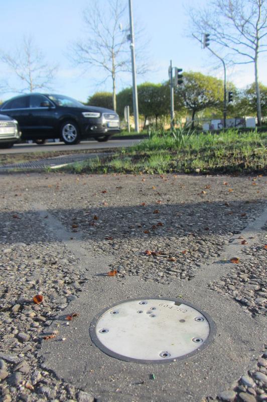 Feste Straßenwetterstation an der Kreuzung Ostring/Käppelestraße in Karlsruhe: Auf dem Radweg eingebaute Sensorik sowie im Hintergrund die Sensorik für die Messung der atmosphärischen Parameter