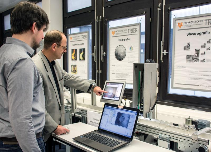 Prof. Dr. Michael Schuth (erster v. rechts) und M. Eng. Christopher Petry (zweiter v. rechts) am Serienüberwachungsprüfstand im Technikum OGKB der Hochschule Trier