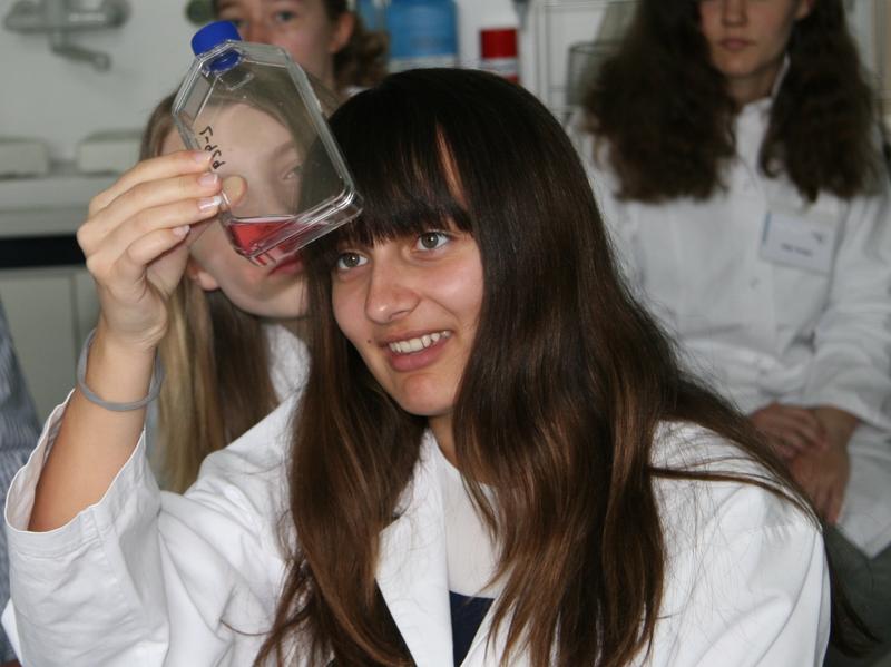 Schülerin Jacey untersucht eine Flasche mit einer Zellkultur-Lösung