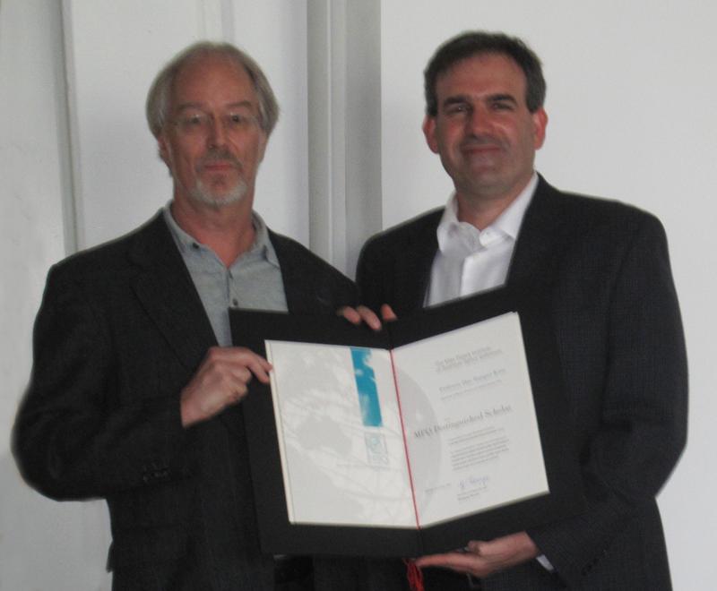 Prof. Gerhard Rempe (links) überreicht die Urkunde an Prof. Dan Stamper-Kurn (rechts).