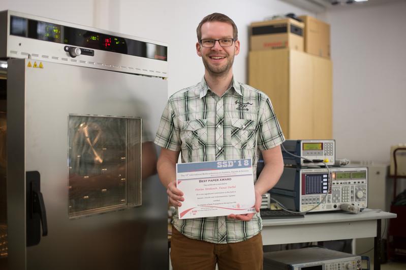 Florian Strakosch im „Smart Diagnostics“-Labor der HTWK Leipzig. In der Klimakammer (links) wurde das Getriebe simuliert, die Messtechnik (rechts im Bild) erzeugte und wertete die Funksignale aus. 