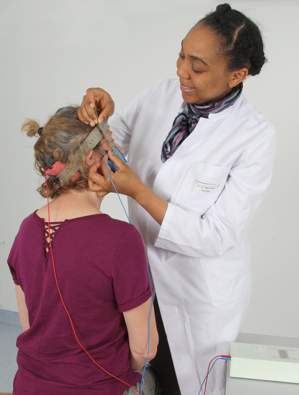 Dr. Carine Nguemeni beim Anlegen der Vorrichtung zur transkraniellen Gleichstromstimulation.