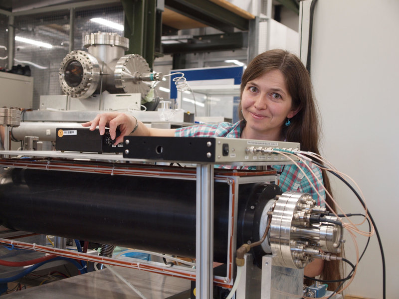 Dr. Eve Stenson an der Teilchenfalle, die hier von einem Magneten (schwarz) umgeben ist.