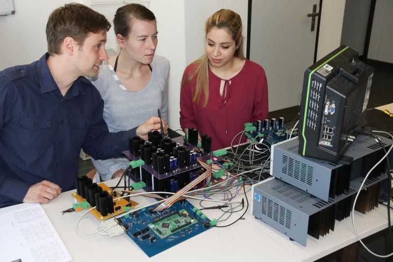 Von links: Dr. Sidney Gierschner (wiss. Leitung des Projektes), die Doktorandinnen Magdalena Gierschner und Nastaran Fazli zeigen Demonstratoren für Mehrpunktumrichter im Schutzkleinspannu