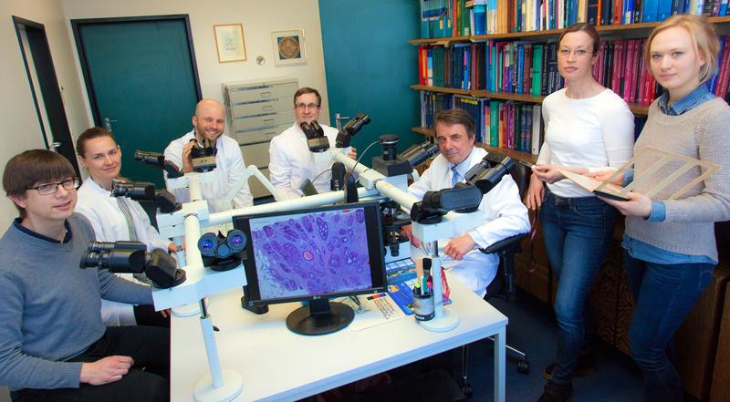 Professor Dr. Hans H. Kreipe (dritter von rechts) mit seinem Team im Institut für Pathologie. Im Vordergrund ist ein Brustkrebs unter dem Mikroskop zu sehen. I