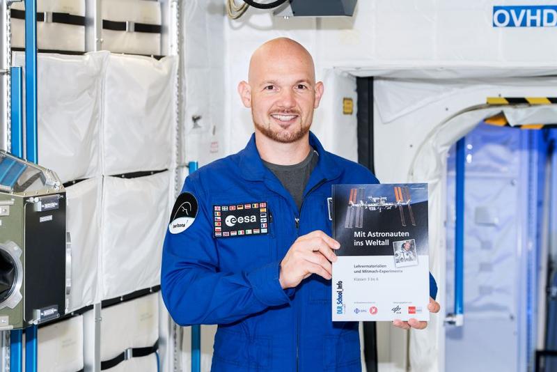 Alexander Gerst mit dem Schulheft „Mit Astronauten ins Weltall“