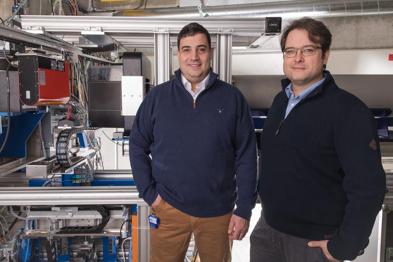 Die beiden PSI-Forscher Christian Grünzweig (links) und David Mannes an dem Experimentieraufbau mit Neutronenstrahlen, an dem die Durchleuchtungsbilder der Fertigspritzen angefertigt wurden.