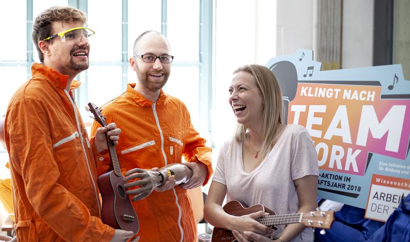 Gesangsteam singt gemeinsam zur großen Mitsing-Aktion „Klingt nach Teamwork“ im Wissenschaftsjahr 2018 und begleitet mit Ukulelen.