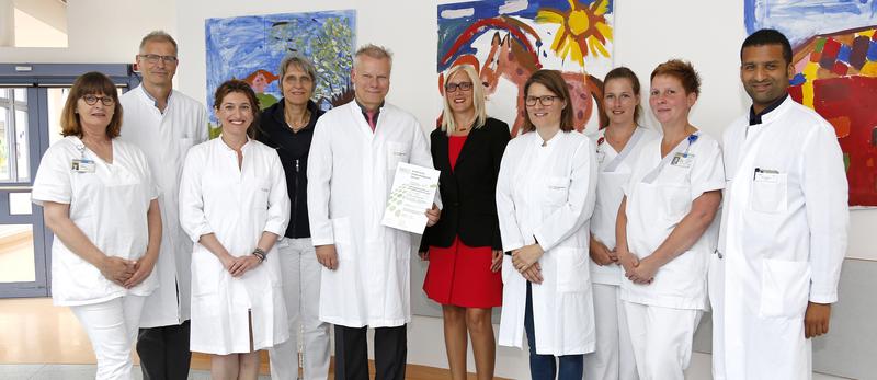 Prof. Dr. Arndt Borkhardt (mit Urkunde) und seine Mitarbeiter sind stolz auf das Gütesiegel der Deutschen Krebsgesellschaft.