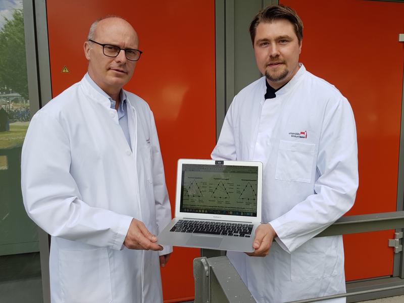 Prof. Dr. Markus M. Nöthen (links) und Dr. Andreas Forstner mit einer Abbildung, wie verschiedene psychische Erkrankungen genetisch zusammenhängen. 