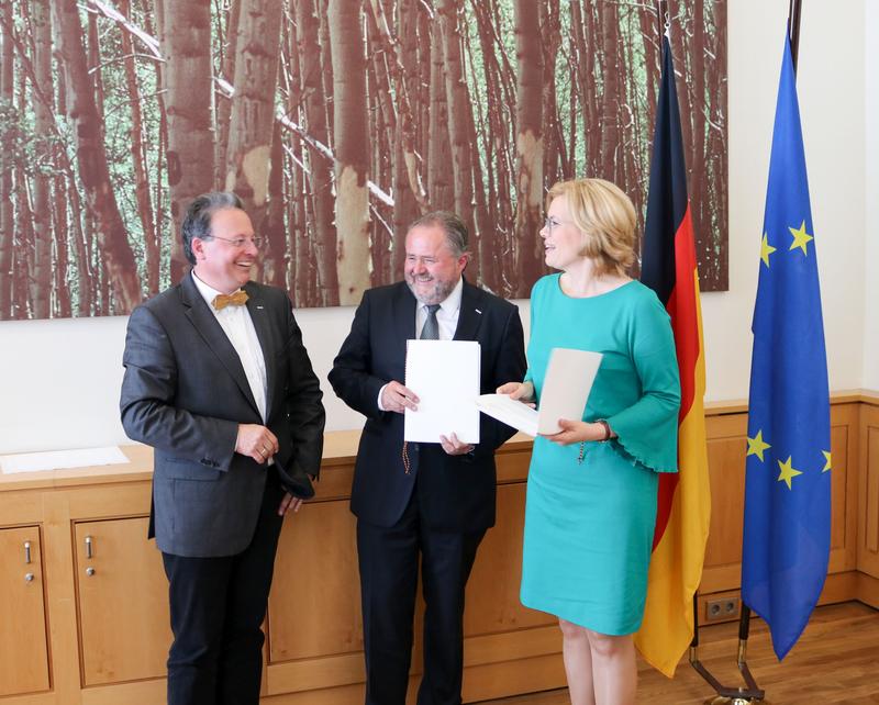 Bundesministerin für Ernährung und Landwirtschaft Julia Klöckner (rechts) übergibt Professor Dr. Eberhard Hartung (ganz links), KTBL und CAU, und Dr. Martin Kunisch, KTBL, den Förderbescheid.