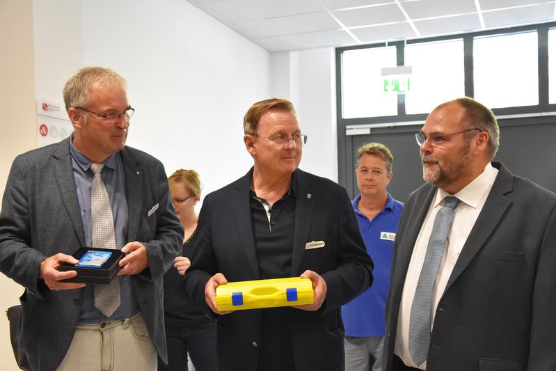V.l.: Prof. Dr. Jens Bliedtner mit dem Präsent des Ministerpräsidenten; Bodo Ramelow mit dem 3D-Druck-Zukunftsmodell der EAH Jena (im gelben Koffer), überreicht von Rektor Prof. Dr. Steffen Teichert
