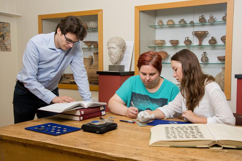 Projektleiter Marc Philipp Wahl und die Studentinnen Katrin Hecht und Helena Huber arbeiten am digitalen Münzkabinett. 