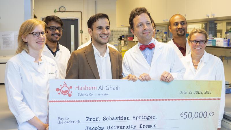 Hashem Al-Ghaili, Wissenschaftskommunikator und Social-Media-Star, übergibt Prof. Dr. Sebastian Springer von der Jacobs University Bremen seine Spende. 