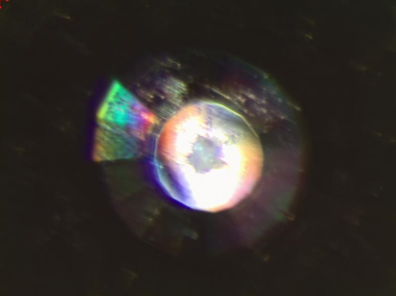 Mikroskopaufnahme durch einen der beiden Stempeldiamanten auf das auf 27 GPa komprimierte feste CO2 (dunkler Fleck Bildmitte).