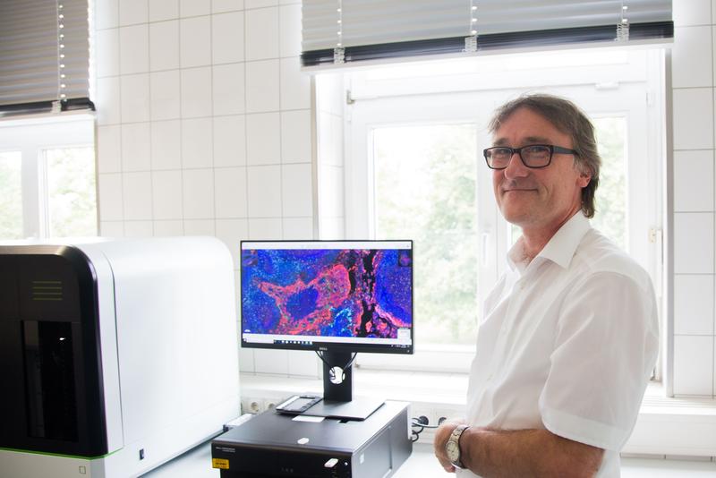 Priv.-Doz. Dr. Norbert Naß, wissenschaftlicher Mitarbeiter des Instituts für Pathologie, vor dem Bildschirm des neuen multispektralen Mikroskop-Systems.