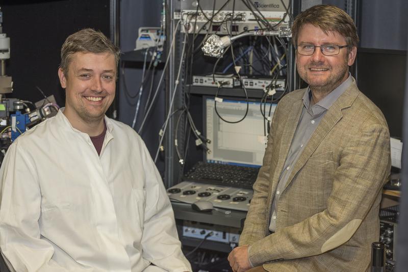 Optischer Sensor für den Botenstoff Glycin: Prof. Christian Henneberger (re) und sein Bonner Kollege Dr. Daniel Minge (li) schauen im Labor mit Hilfe eines Mikroskops dem Hirngewebe bei der Arbeit zu