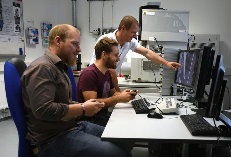 Christian Dolle, Peter Schweizer und Prof. Dr. Erdmann Spiecker (von links nach rechts) beim anipulieren von Versetzungen an ihrer Nano-Werkbank, einem erweiterten Elektronenmikroskop.