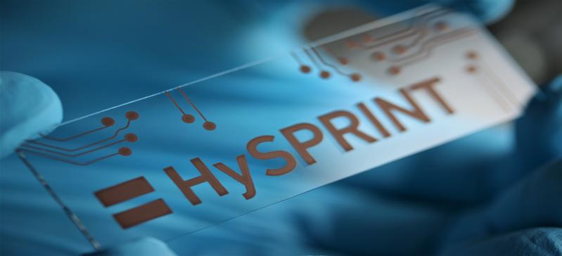 Das aus einer Kupferlösung aufgedruckte HySPRINT-Logo (Helmholtz Innovation Lab) symbolisiert, wie sich dünnste Materialschichten kostengünstig herstellen lassen