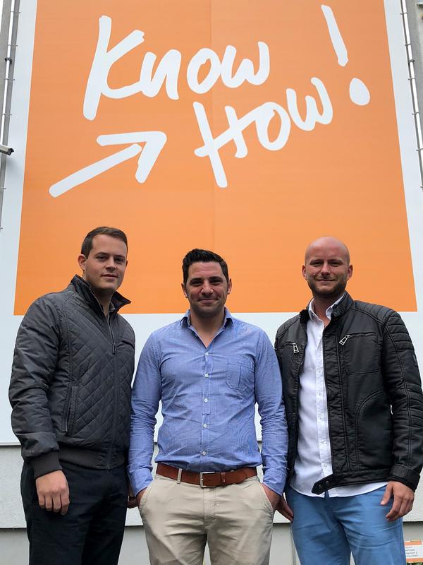 Foto von links: Dominik Kagerer, Tobias Löwe und Sebastian Czaplicki. (Im Hintergrund das orangene Banner befindet sich auf der Hauswand des IGZ.) 