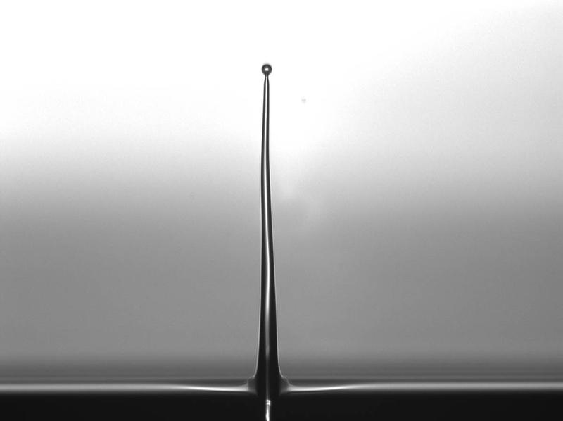 Moment-Aufnahme eines Jets nach einer Verzögerungszeit von 10 µs und einer Pulsenergie von ca. 5 µJ: Ein 0,5 mm langer gleichmäßiger Jet mit einer Dicke von ca. 50 µm verjüngt sich nach oben