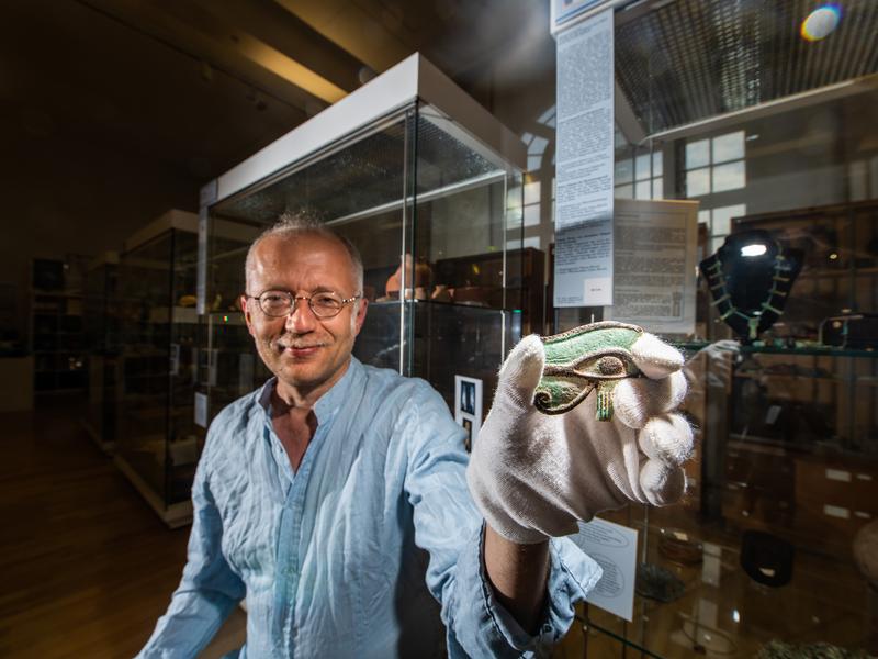 Der Ägyptologe Prof. Dr. Ludwig Morenz von der Universität Bonn mit einem Amulett in Form eines Udjat-Auges aus dem 1. Jahrtausend v. Chr. 